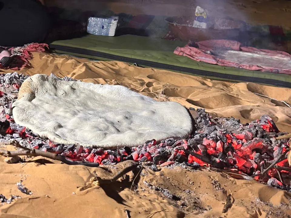 Bread dough baking on hot embers in the sand
