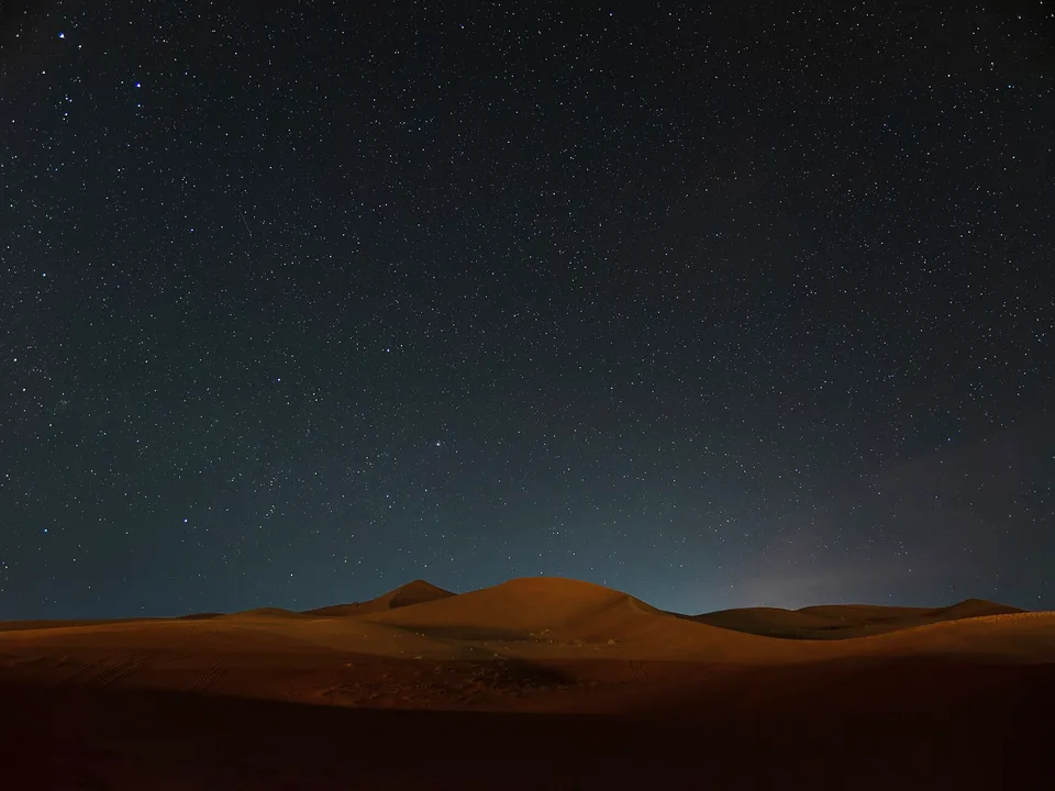 Starry night sky over Sahara dunes